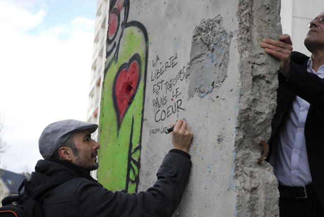 Dibujando en una pieza del Muro de Berlin